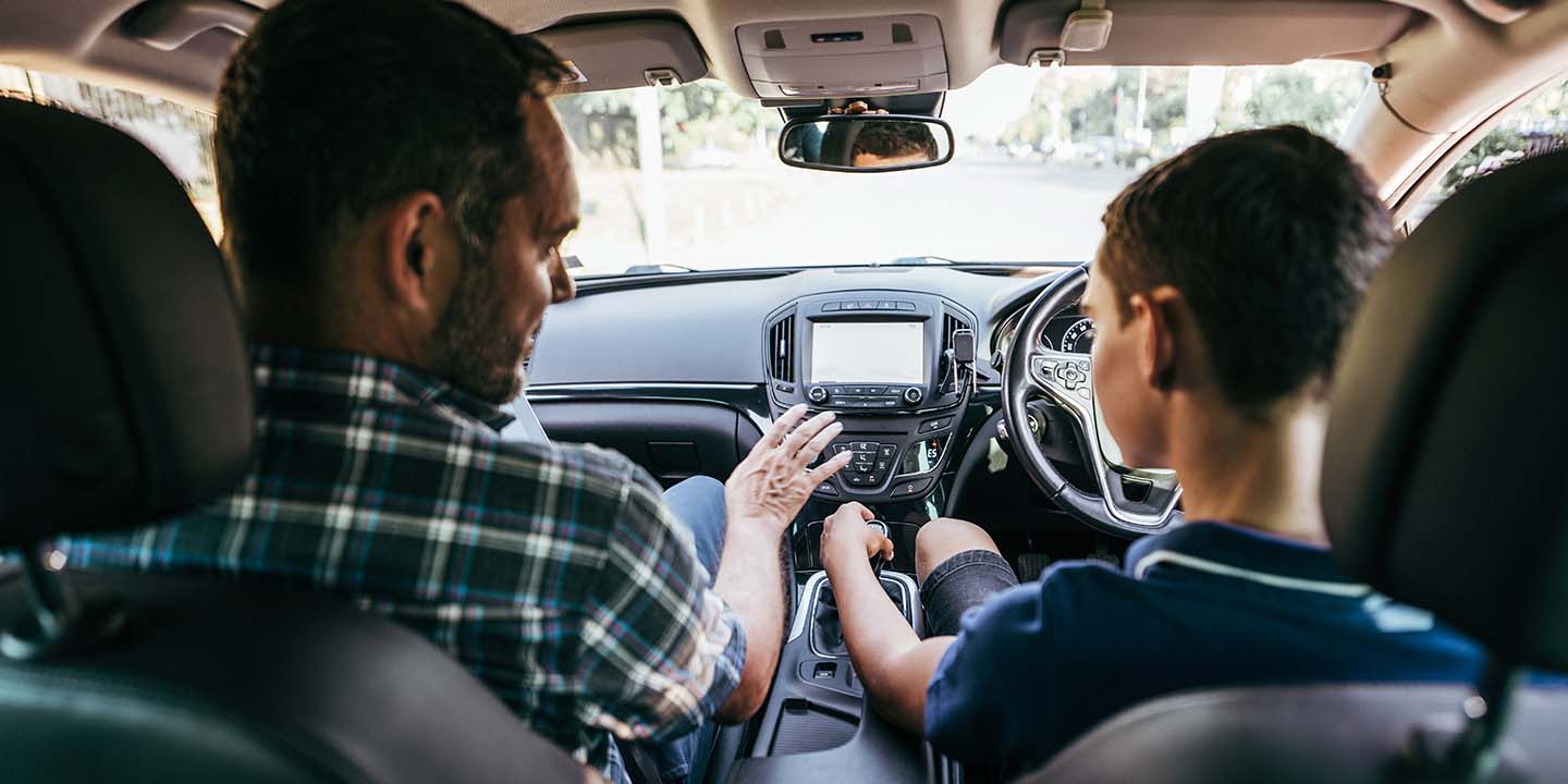 Father teaching son how to drive