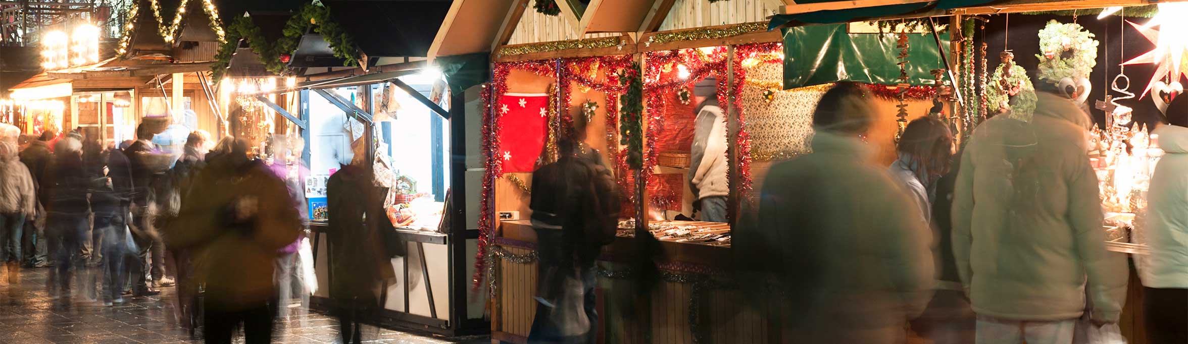  A busy christmas market stall with christmas lights and people huddled nearby