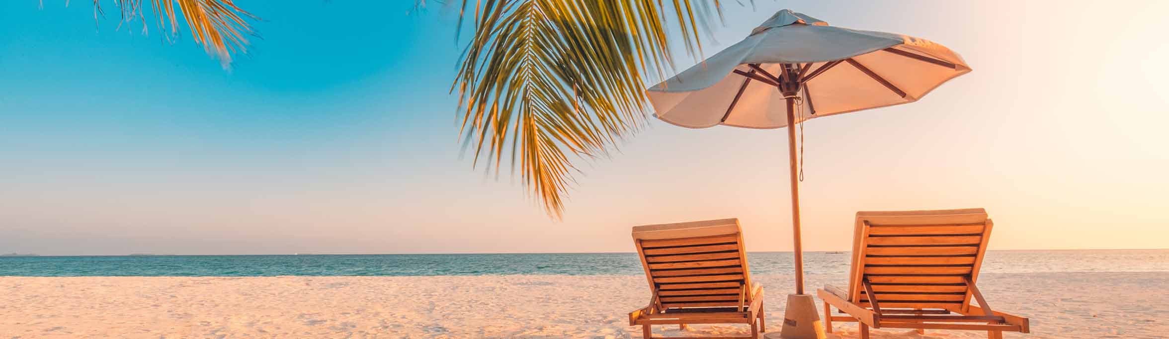  pair of wooden chairs and an umbrella on a beautiful beach